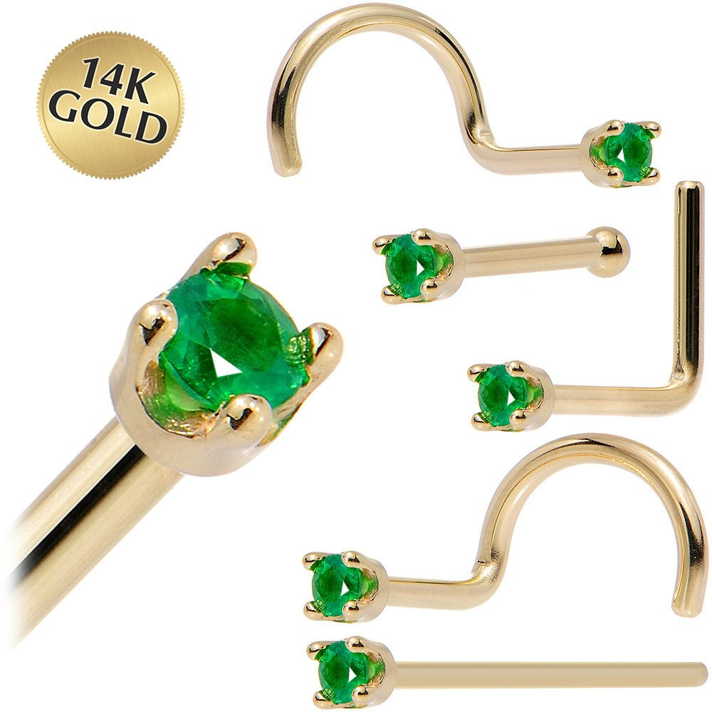 Gold-plated nose studs with green gemstones, shown in multiple styles including a large oval-cut stud and several barbell and hoop-style studs. A gold seal in the top left corner reads '14K GOLD'.
