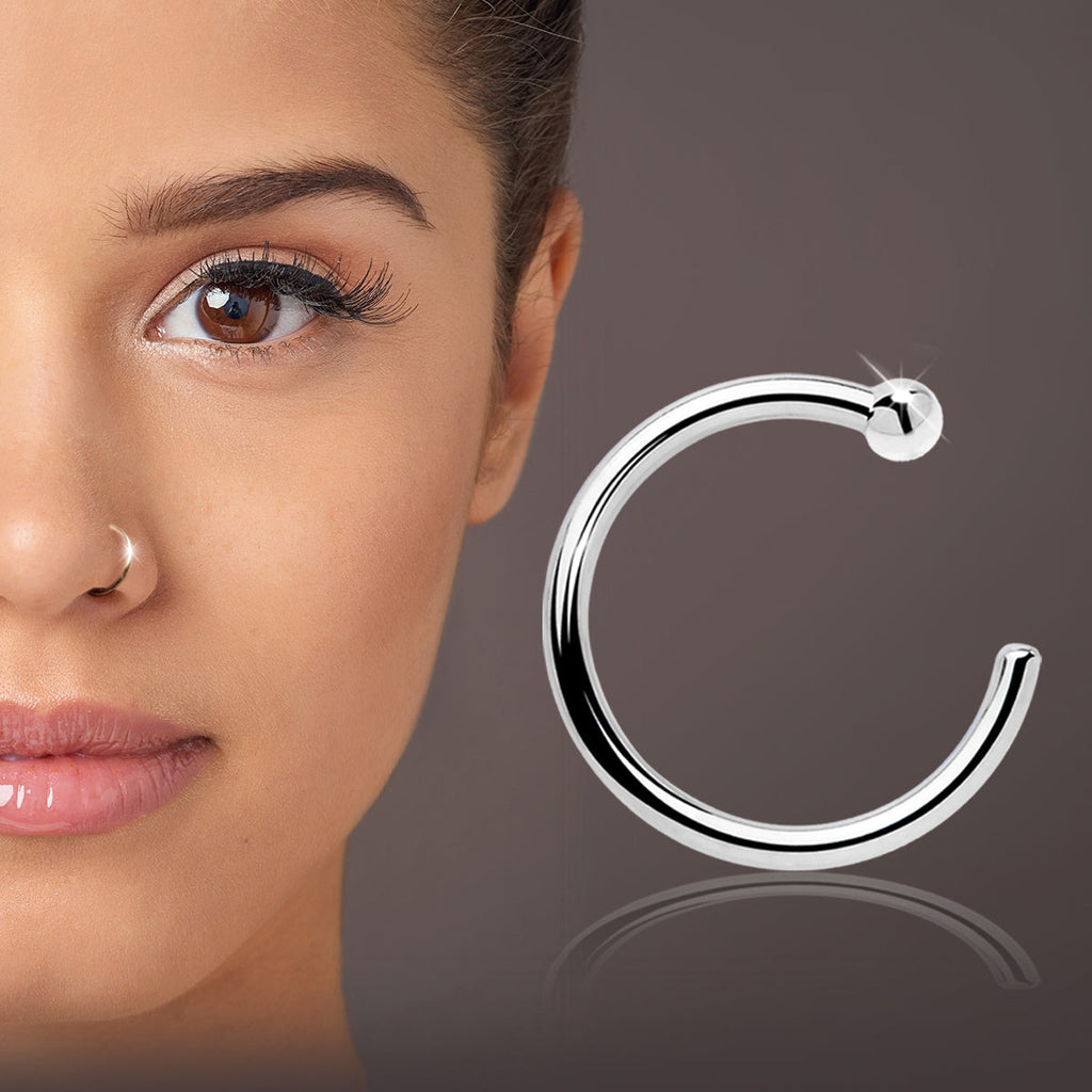 Silver hoop earring displayed next to a close-up of a woman's face with brown eyes.