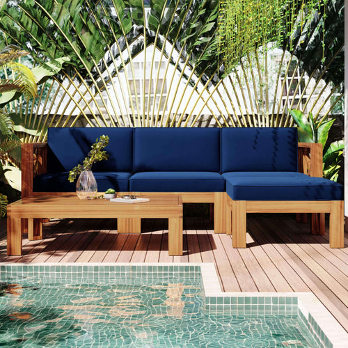 Outdoor patio with blue sofa, wooden table, and pool in the background