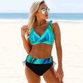 Woman in a colorful bikini and sunglasses on a beach